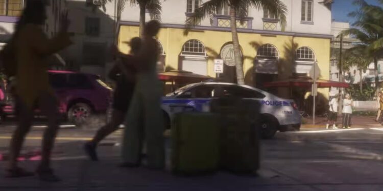 Peatones y un coche patrulla en una calle de Vice City en el tráiler de lanzamiento de GTA VI