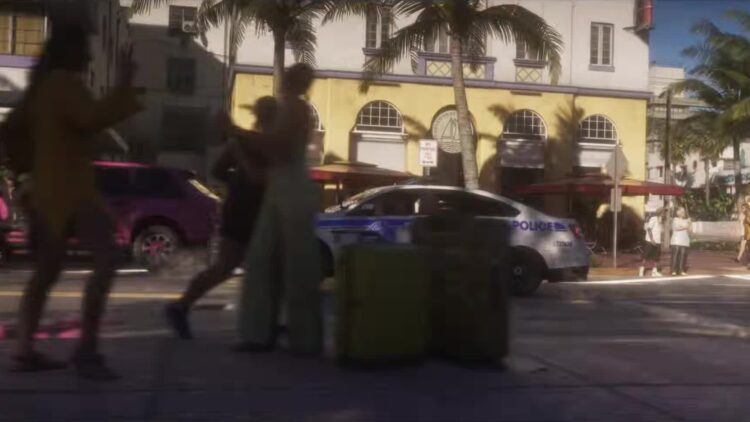 Peatones y un coche patrulla en una calle de Vice City en el tráiler de lanzamiento de GTA VI
